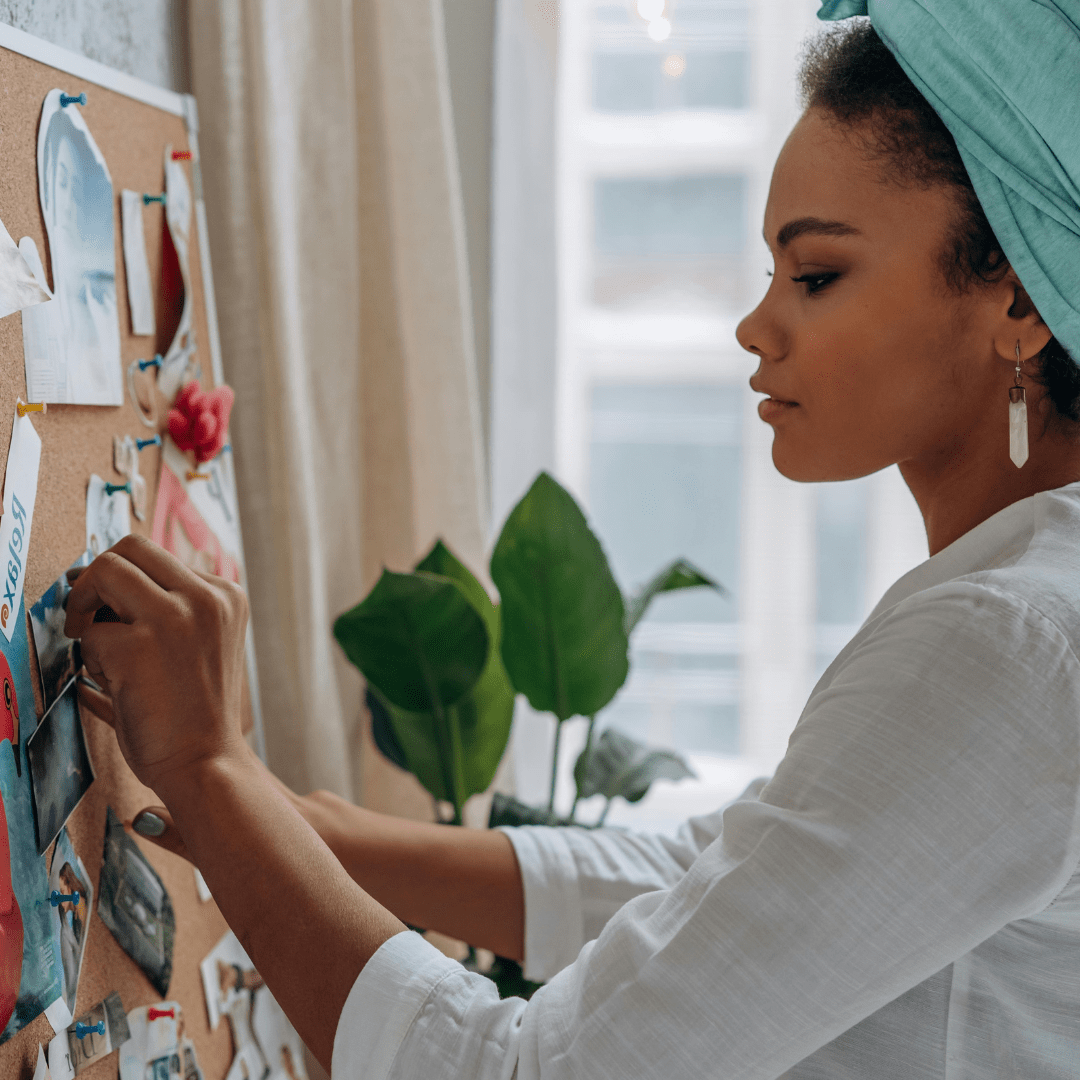 A lady pinning items onto a moodboard.