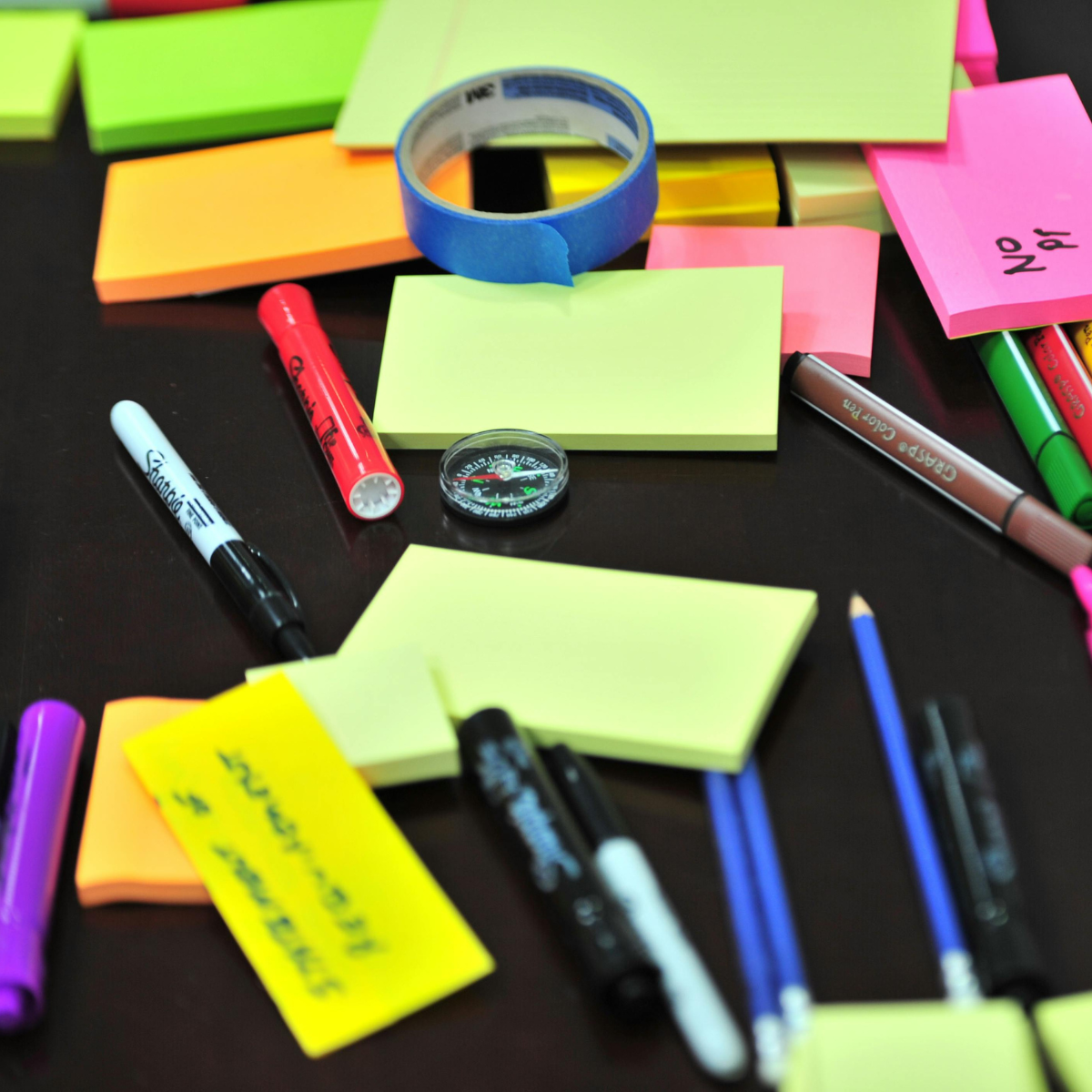A bunch of pens and colourful post it notes